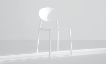 a stylish white chair illuminated from the right side